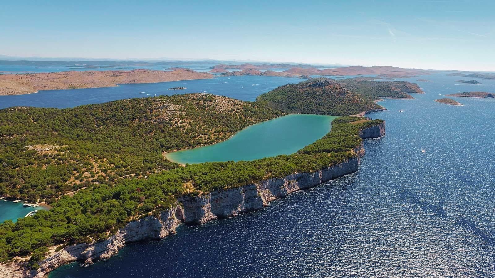 Rocky formation on water with emerald lakes and green forests