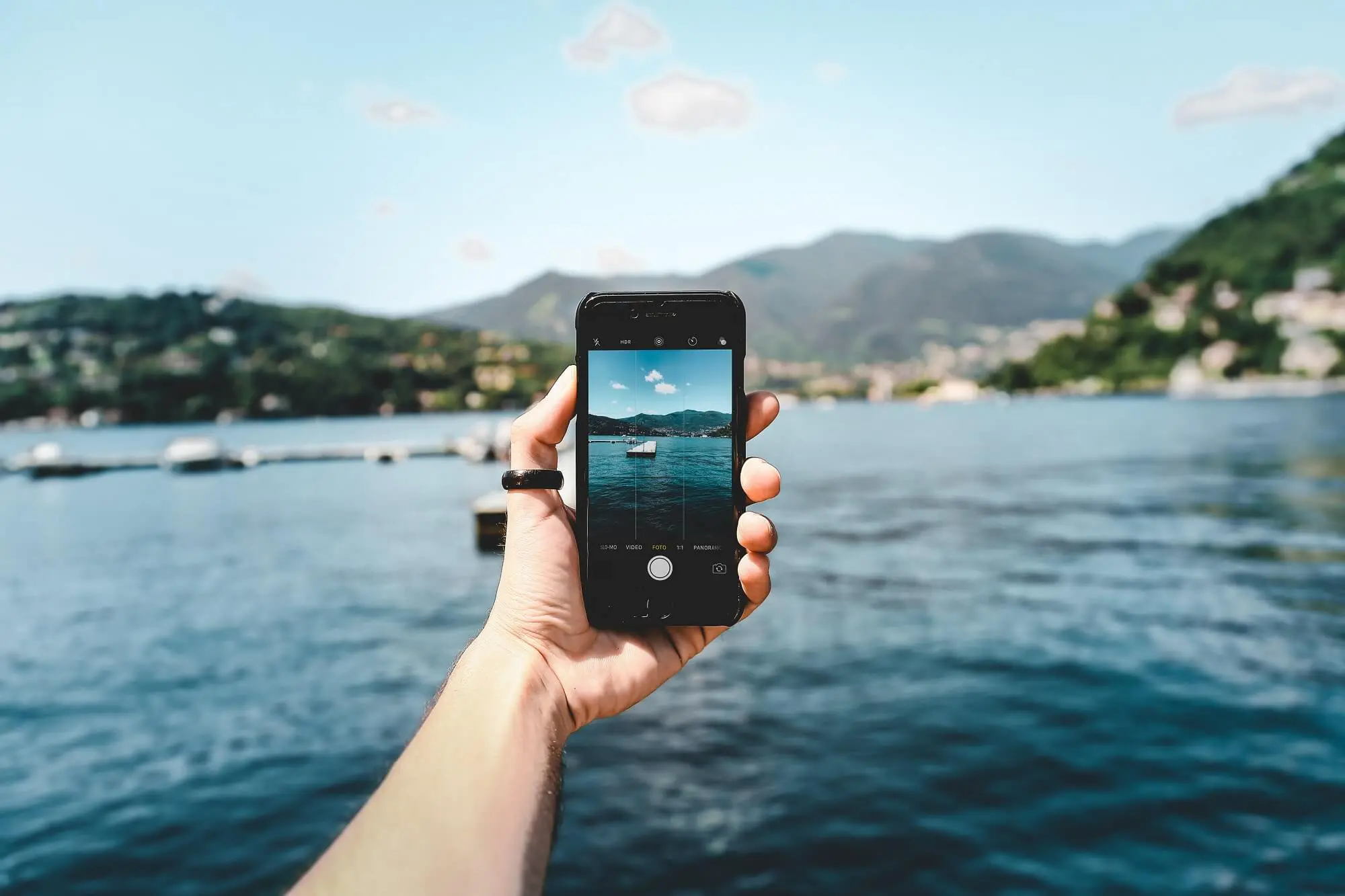 Hand holding an iPhone and taking a photo of a deck